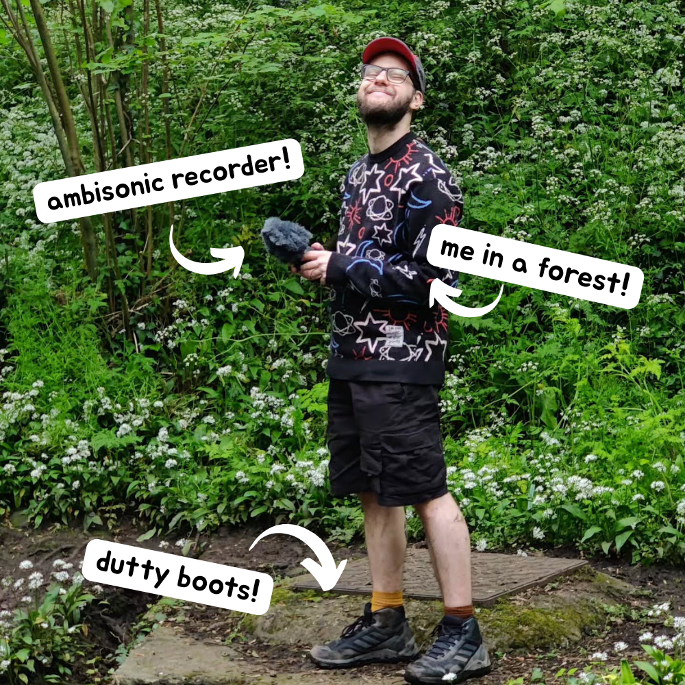 Luke stood smiling in a forested area while holding a portable ambisonic recorder. Text popouts point to different picture features. #1 reads 'ambisonic recorder'. #2 reads 'me in a forest!'. #3 points to Luke's boots and reads 'dutty boots!'
